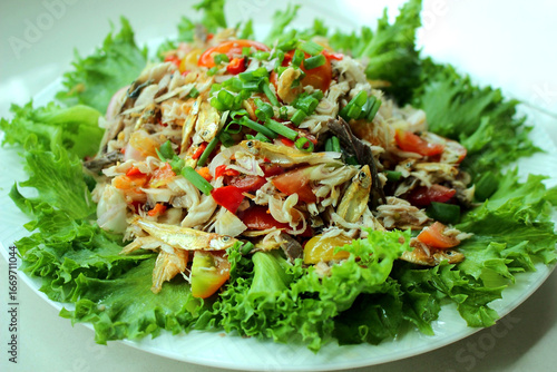 Traditional Thai spicy mackerel and anchovy salad with fresh herbs and vegetables, authentic homemade Thai cuisine, rustic Asian local food photography