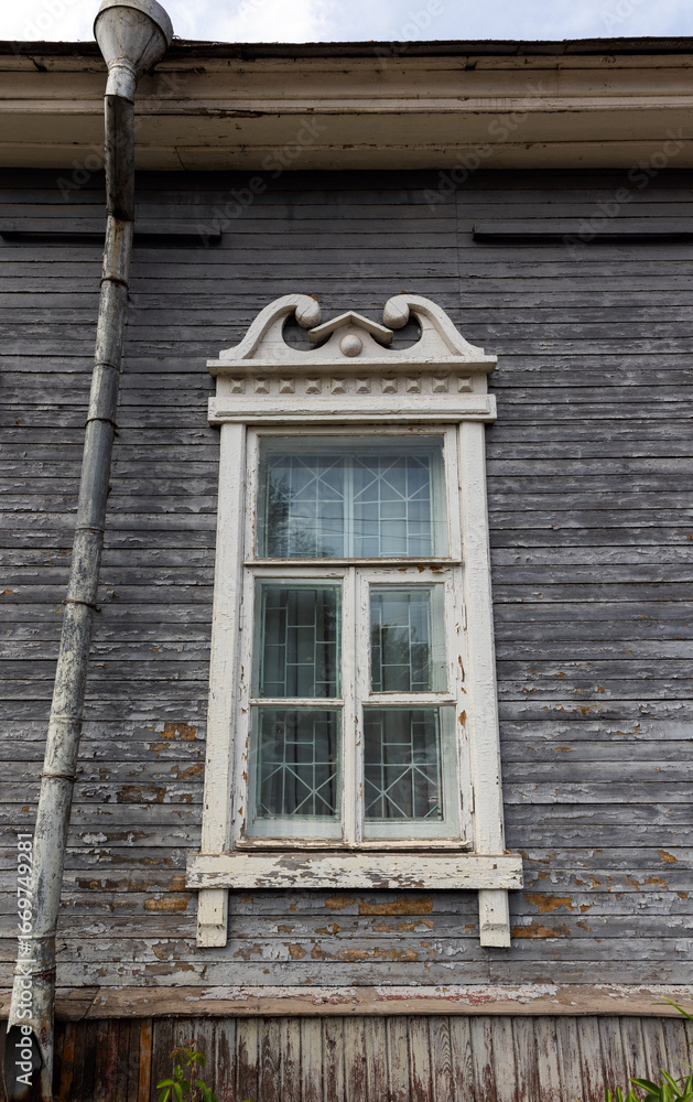 Fototapeta premium Vintage wooden house exterior showcasing a single white-framed window