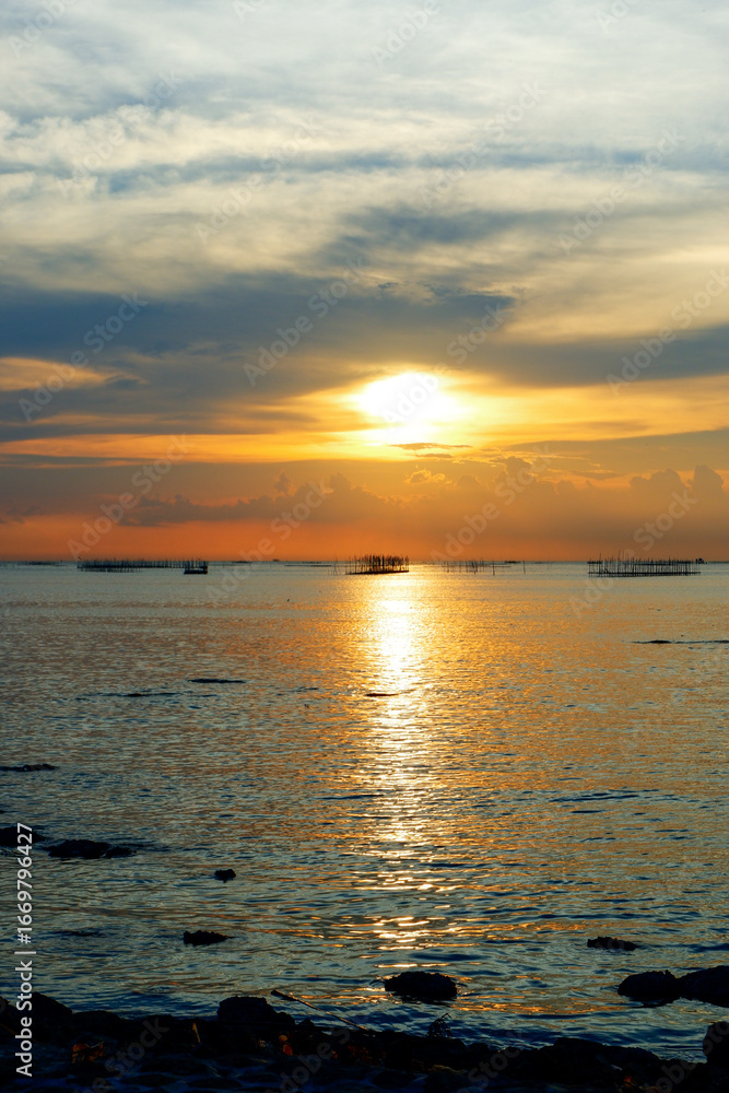 Fototapeta premium sunset in the sea. Beautiful colorful sky and cloud in twilight time background. Orange fluffy clouds and sun sunlight reflection in the blue sky.