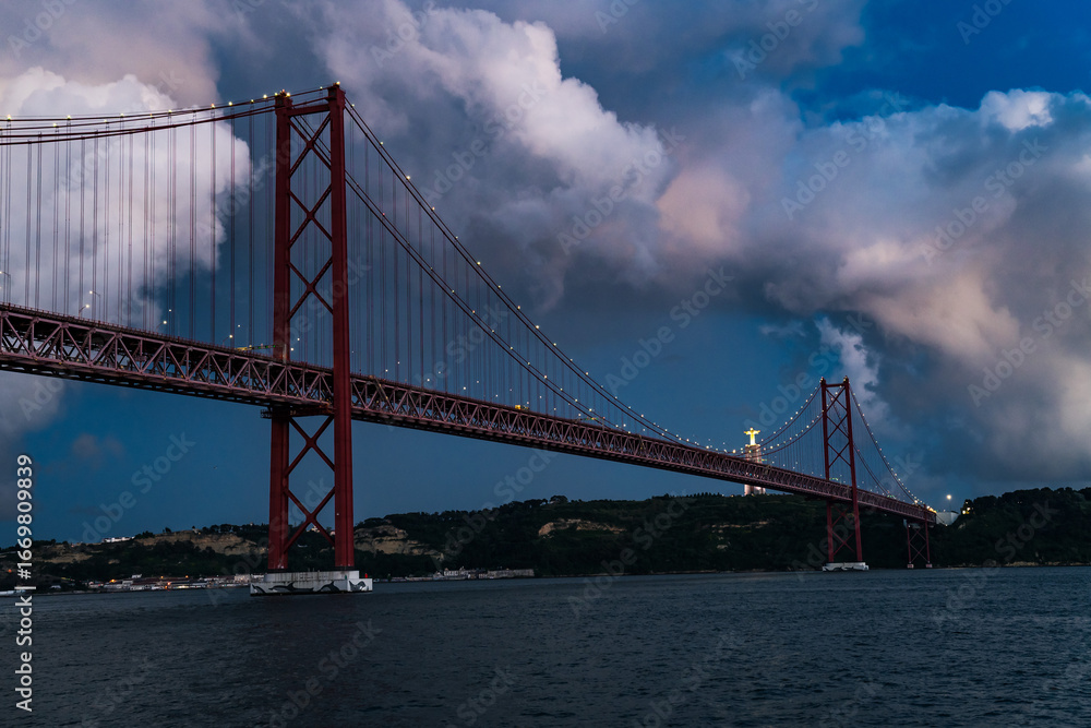 Fototapeta premium The 25th of April Bridge and the Jesus Cristo Rei Monument in Lisbon, Portugal.