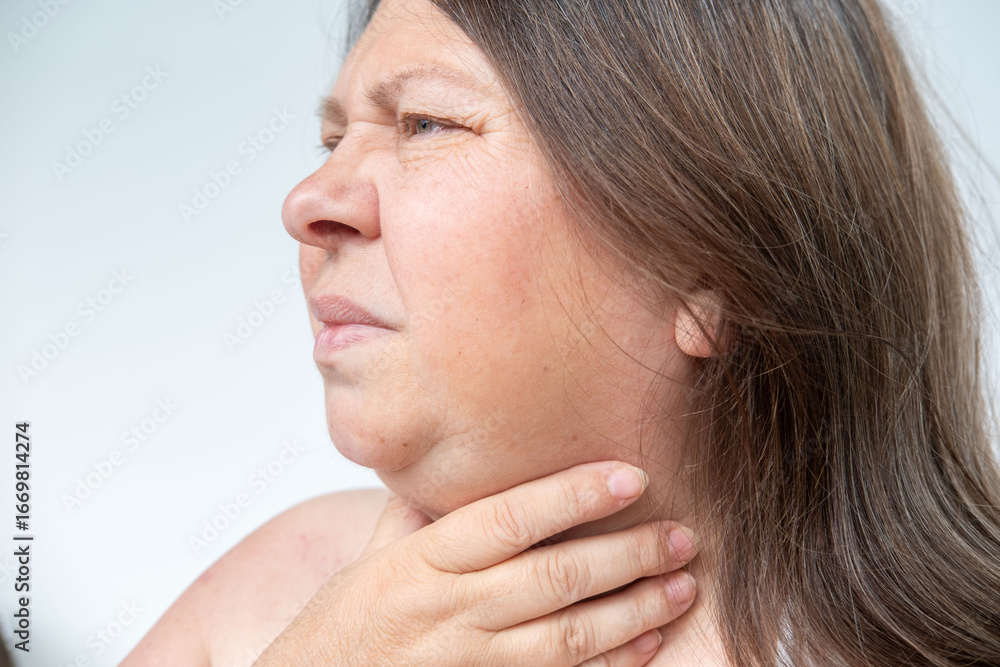 Obraz premium Adult woman indicating health problem in throat area, Female with neck pain, sore throat, emotional strain, health issue, seasonal illness, Symptoms infection