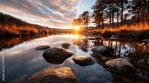 A breathtaking sunset reflecting golden hues on a calm water surface surrounded by trees, capturing the essence of tranquility and beauty in a serene natural setting.