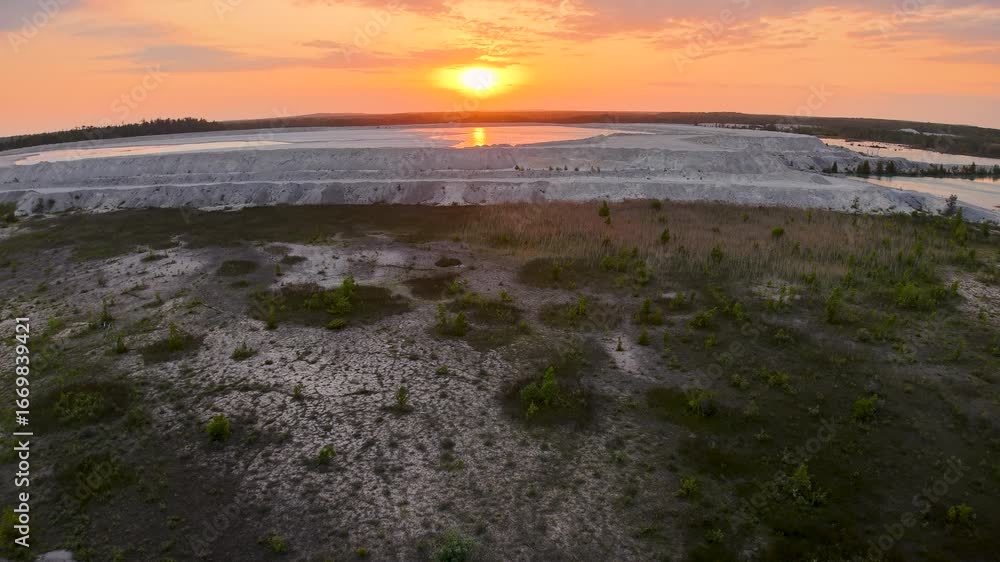 Aerial drone shot of a coastal shoreline with tidal flats and vegetation illuminated by a golden sunset. Aerial drone shot of a coastal shoreline with tidal flats and vegetation illuminated by a golden sunset.