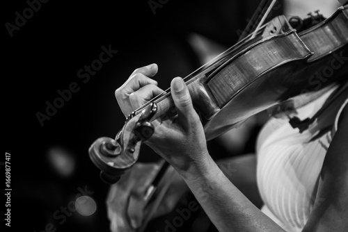  Hands of a woman playing the violin in black and white