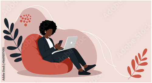 Professional Black woman multitasking on laptop and smartphone while comfortably working remotely on a beanbag chair. Ideal for business, technology, and modern lifestyle concepts.