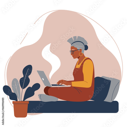 Focused senior woman with headphones uses a laptop comfortably at home, embodying remote work, online learning, and modern digital lifestyle.