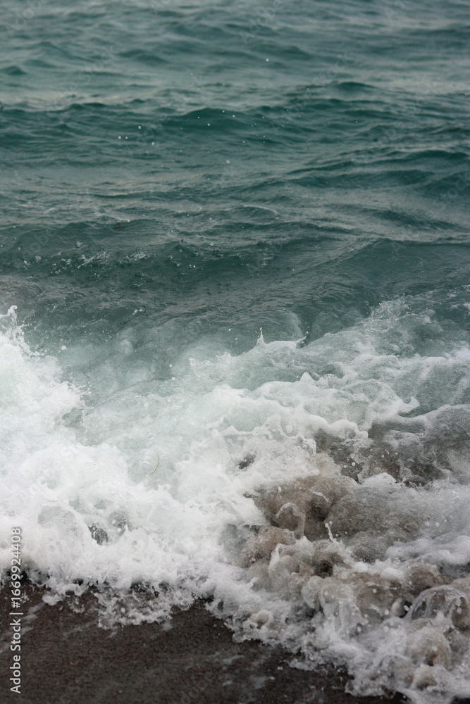 Fototapeta premium Stormy weather at sea, waves close-up. Bulgaria, Black Sea near the city of Pomorie. Waves on the sea near the shore in the evening. Sea evening landscape. Concept of vacation at the resort