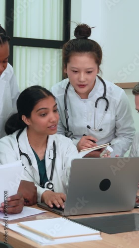 Medical team reviewing patient data on laptop, sharing insights, collaborating closely, demonstrating professional healthcare communication and teamwork