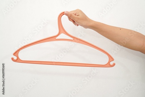 woman's hand holding a clothes hanger isolated on a white background