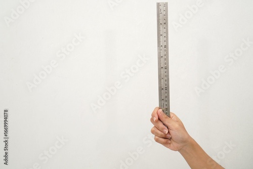 Women Hand holding a stainless steel ruler on isolated white background. Precision measuring tool for length and drawing. Close up