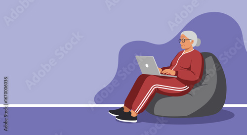 Elderly woman comfortably using a laptop on a bean bag chair, symbolizing seniors embracing technology for learning, communication, or leisure at home.