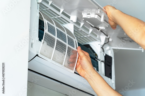 Repairmans hands changes cleaning filter in air conditioner. Air conditioning maintenance. Purification and repair of cooling system