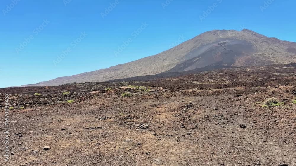 A stunning photo of a breathtaking volcanic landscape with rocky terrain and vibrant greenery under a clear blue sky A stunning photo of a breathtaking volcanic landscape with rocky terrain and vibrant greenery under a clear blue sky