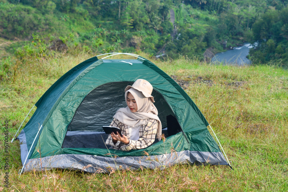 custom made wallpaper toronto digitalYoung brown skinned Asian woman reading a book while camping
