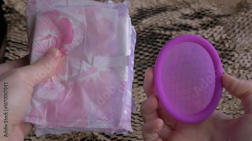 Silicone menstrual disc and sanitary pads in hands, showcasing Eco-friendly choice. Silicone menstrual disc, reusable intimate hygiene. Choice, Economy, Health, Saving . Menstruation concept