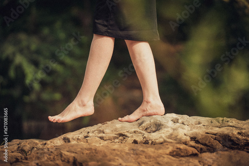 une femme baladant pieds nus sur un rocher