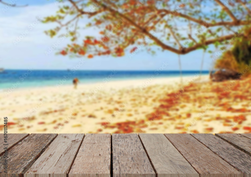 Fototapeta premium Wooden table top on the beach or sea.Party on the beach sunshine time concept.For montage product display or design key visual layout.View of copy space.