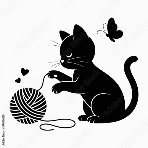 Playful black kitten chasing yarn and butterfly