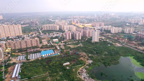 Aerial drone shot showing the outskirts of gurgaon with water logging ponds and marshes created by the monsoon surrounded by temporary slum residences and construction sites