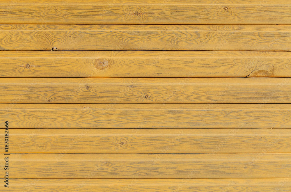 Fototapeta premium Wooden surface with a yellow hue. The wood appears to be old and has a worn texture. Scene is rustic and nostalgic, evoking a sense of warmth and comfort