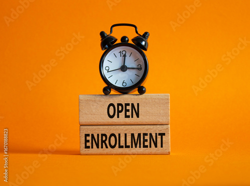 Open Enrollment symbol. Wooden blocks with words Open Enrollment. Beautiful orange background with alarm clock. Business and Open Enrollment concept. Copy space.