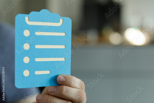 Hand holding blue checklist...
