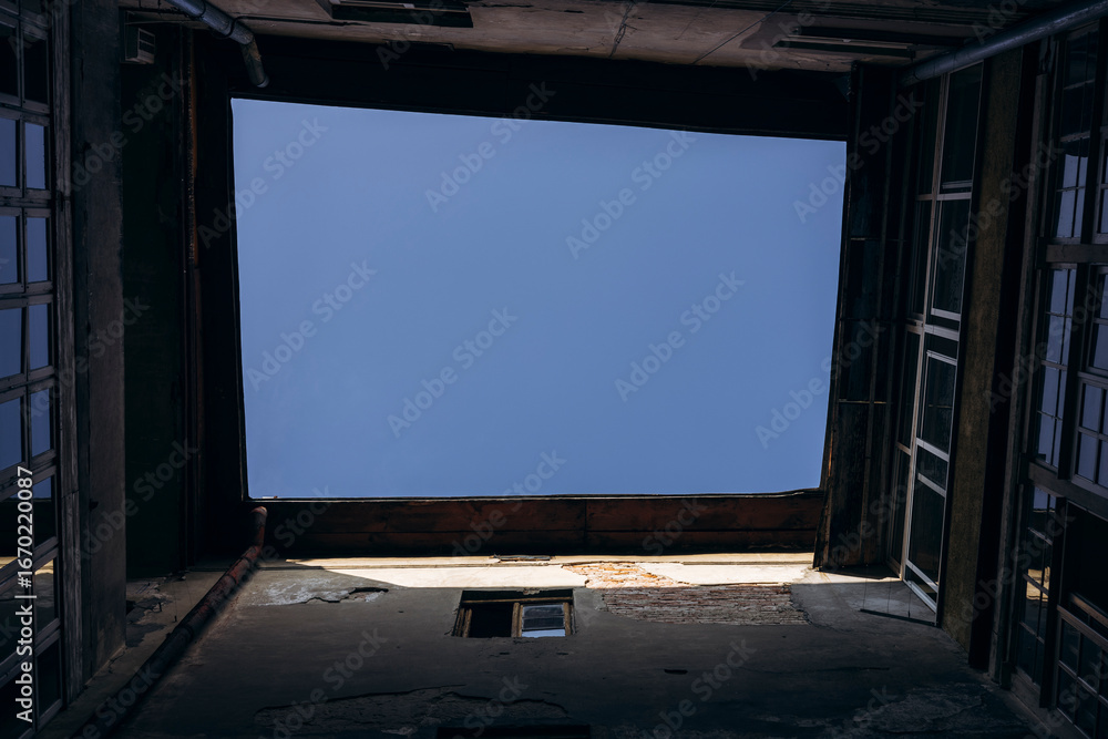 Fototapeta premium Upward view, the sky from an old inner courtyard, surrounded by building walls.