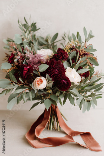 Lush fall bouquet with burgundy dahlias, white roses, and eucalyptus greenery tied with a velvet ribbon