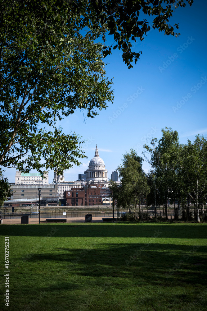 Obraz premium St Paul's cathedral seen between greenery from the South Bank