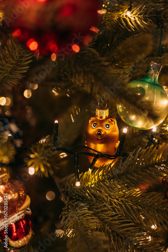 Photography Christmas tree decorated with a golden Winnie the Pooh ornament among glowing fe