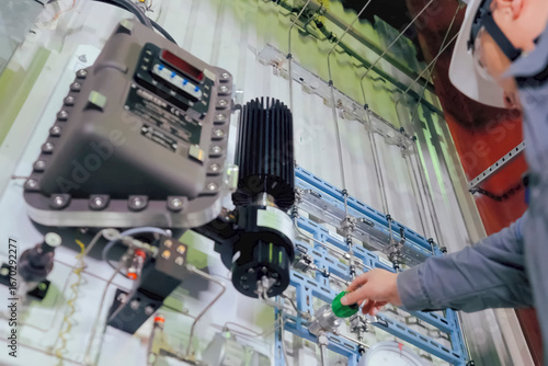 Technicians turning pressure regulator on the monitoring and control panel in the LNG plant
