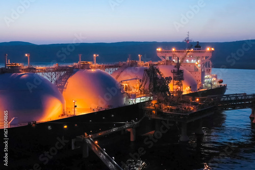 tanker with liquefied natural gas in a port with a fueling terminal.