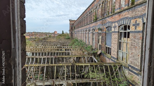 Rydale Mill former college in Wigan, UK 12.04.24 Collapsing roof and rubble ruins from upper factory floor open window frame. Derelict industrial mill building abandoned, left to rot. Crumbling view