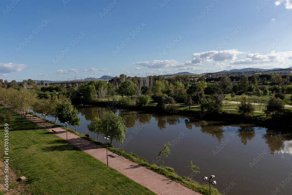 Fototapeta premium Guadiana river flowing through green park in merida, spain