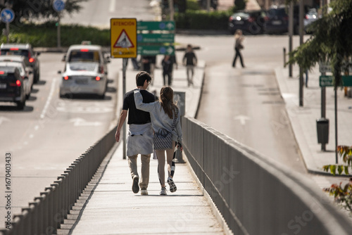 Wallpaper Mural Two young people walking away together through a lively street market, the colorful stalls creating a vibrant background for their love Torontodigital.ca