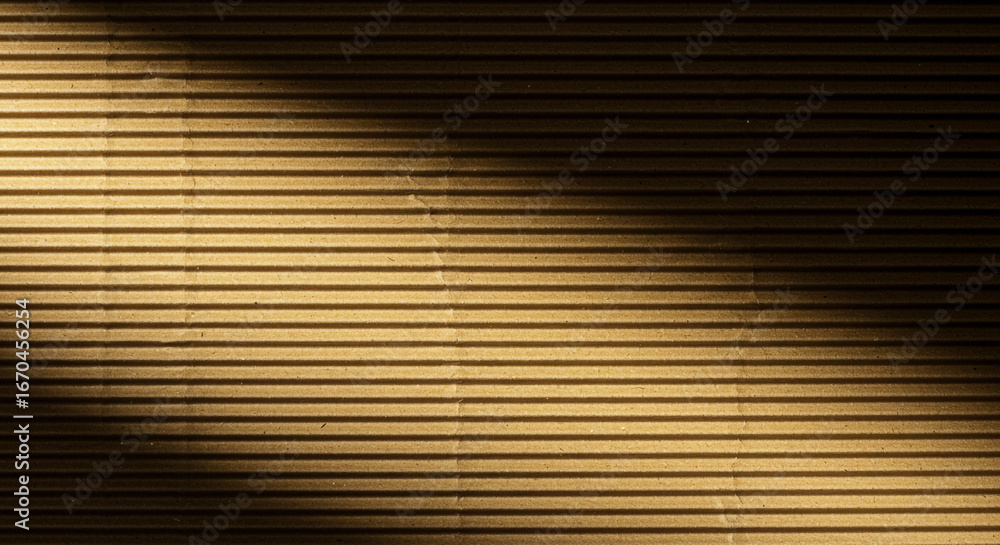 Obraz premium Warm textured corrugated cardboard background with dramatic light and shadow play