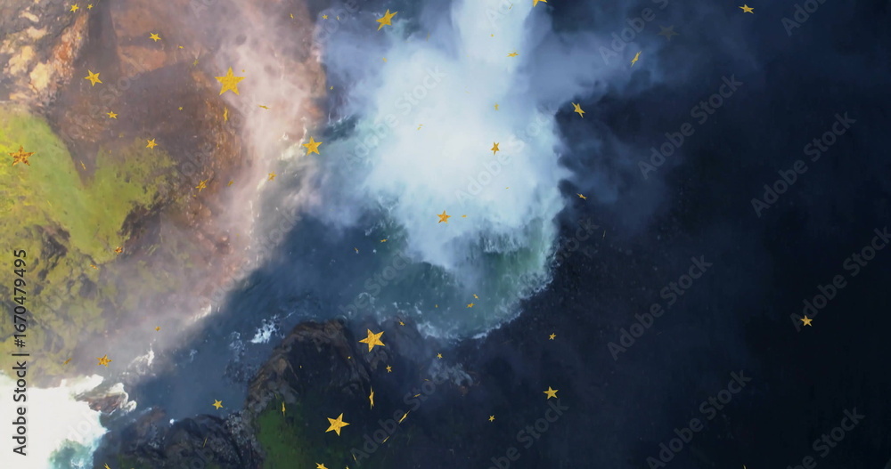 Fototapeta premium Plunging waterfall spilling over mossy cliff rocks in rocky canyon, swirling mist and yellow stars