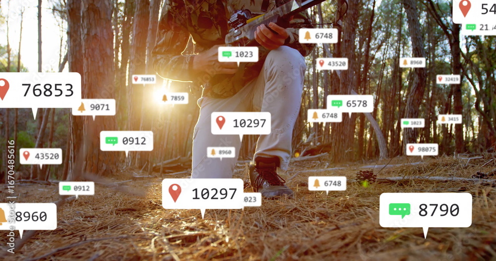 Fototapeta premium Kneeling tactical operative scanning forest floor in pine woods, with rifle and data overlays