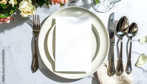 Blank card on round plate with silver cutlery in elegant arrangement