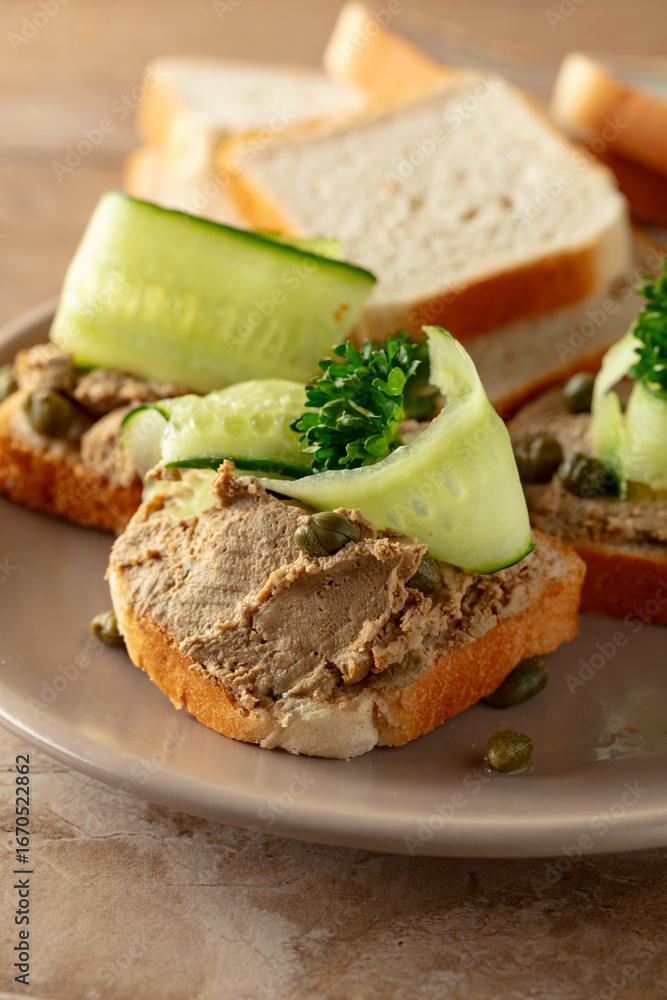 Open sandwiches with pate, cucumber, capers, and parsley. Open sandwiches with pate, cucumber, capers, and parsley.