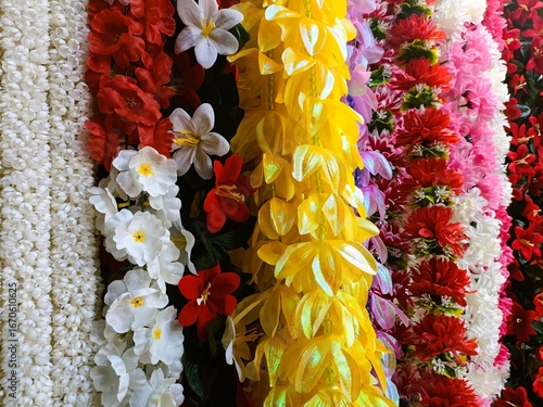 Konstfotografi Colorful display of artificial flowers and garlands at a market booth during day