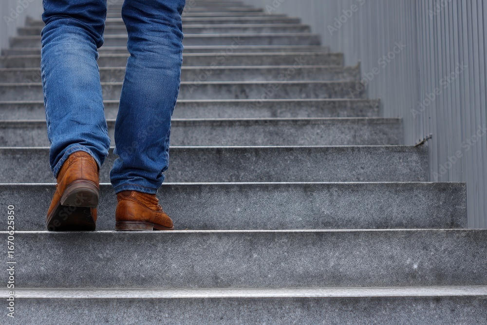 Man in Blue Jeans Ascending Steps: A Close-Up on the Journey Upwards Man in Blue Jeans Ascending Steps: A Close-Up on the Journey Upwards
