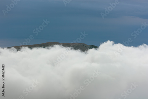 A layer of clouds between two high mountain plateaus. View of the Demerdzhi plateau in Crimea.