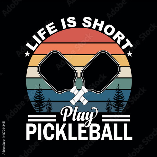 Pickelball Life: A graphic design showcasing a pair of crossed pickleball paddles alongside the optimistic slogan Life is short, play pickleball, perfect for sport