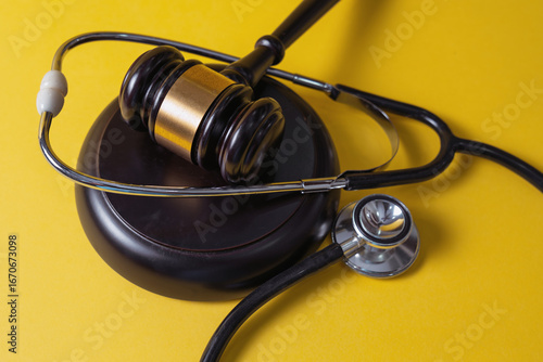 Gavel and Stethoscope on Yellow Background