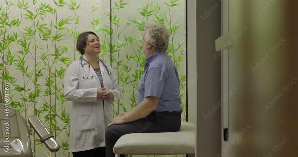Fototapeta premium Senior male patient entering clinic room and approaching smiling female doctor before sitting on examination chair in modern healthcare facility