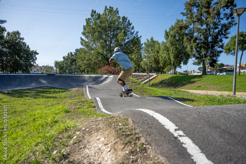 Obraz premium A young Black man riding a skateboard at a pump track