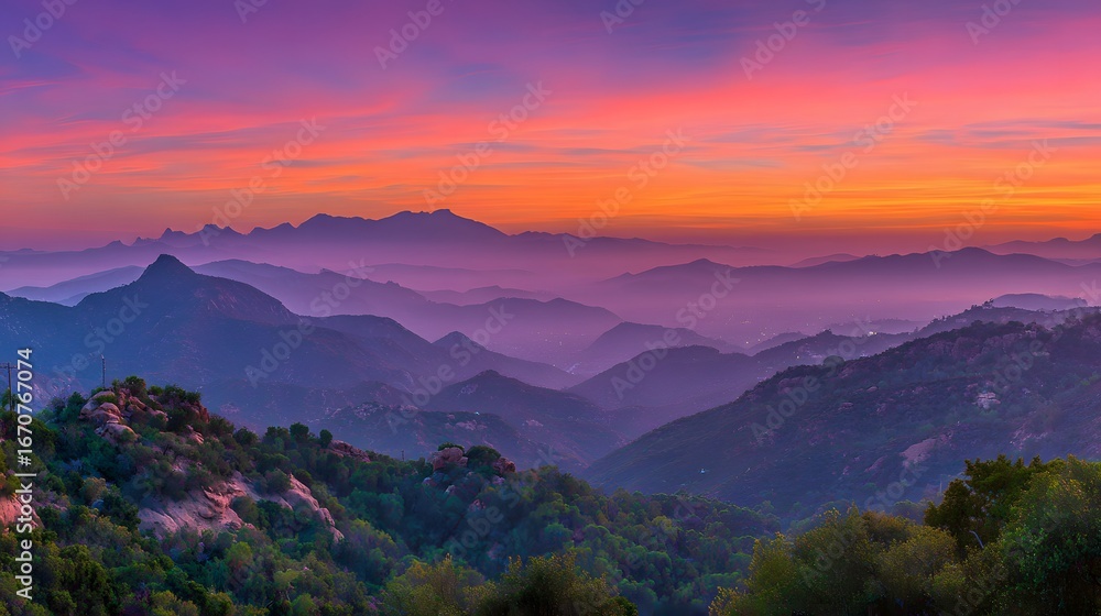Fototapeta premium A breathtaking vista of layered mountains at sunrise, bathed in vibrant hues of purple, orange, and pink, showcasing a tranquil and serene landscape.