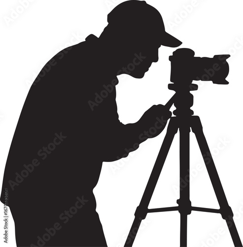 Silhouette of a person wearing a baseball cap operating a camera on a tripod photographer