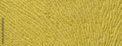 Yellow background from soft fluffy textile material macro. Texture of golden plush fabric backdrop. Wavy pattern